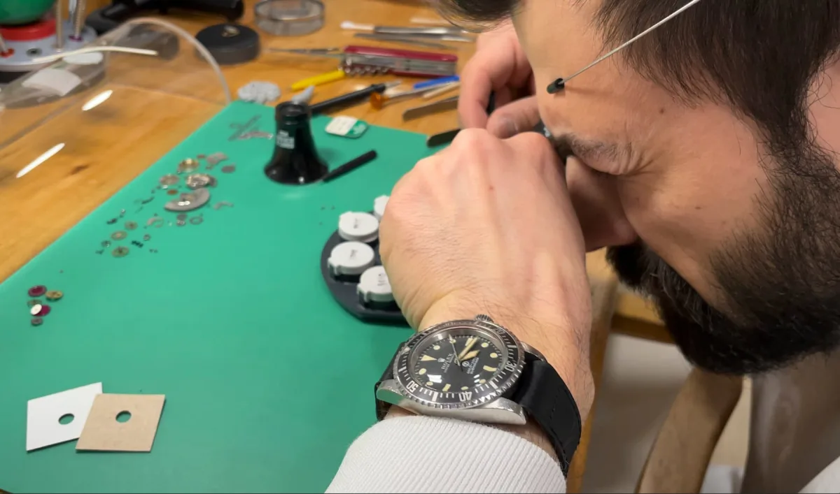 Independent watchmaker repairing an old movement